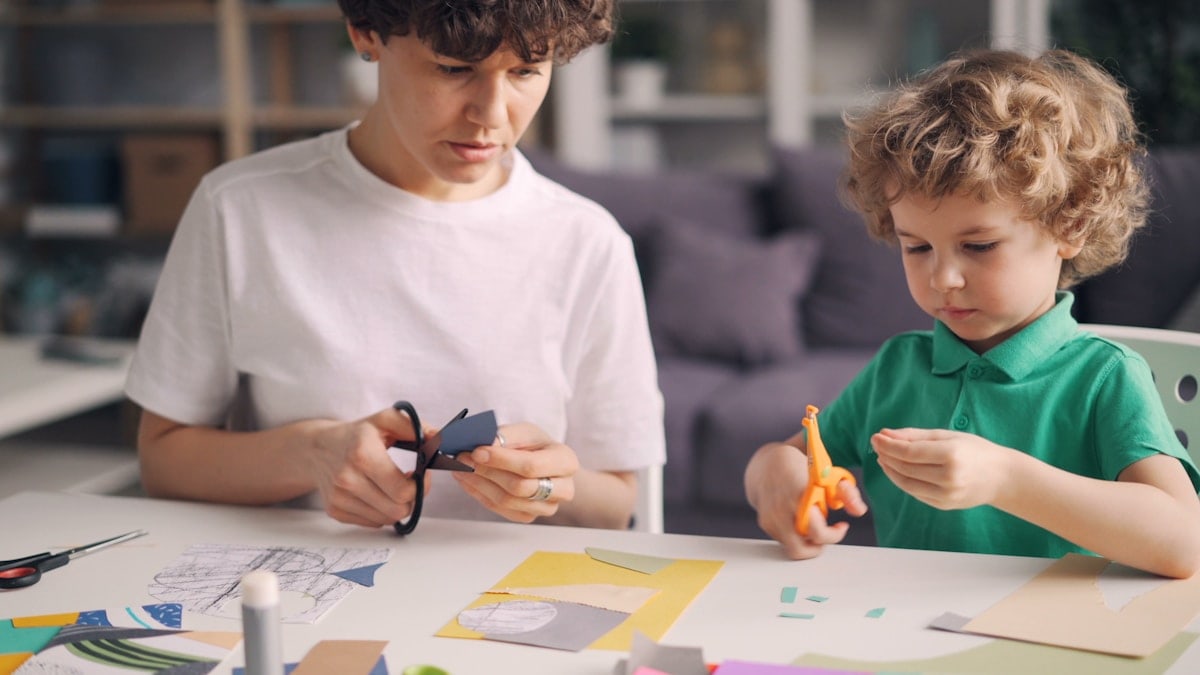 a boy and a boy are making crafts together